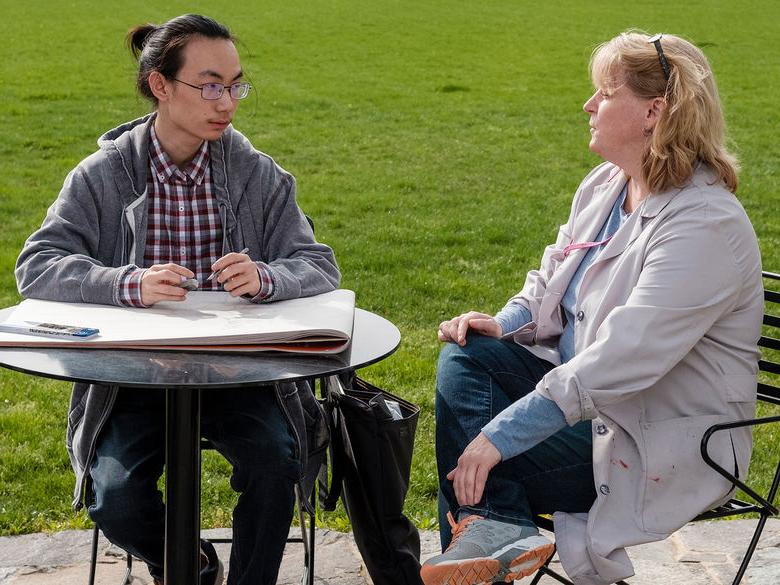 Student 和 professor discussing in the Perkins Plaza